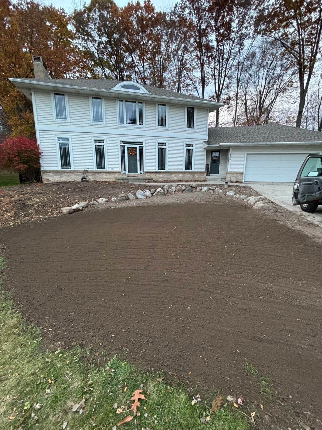Fall property cleanup and lawn renovation in front of a home